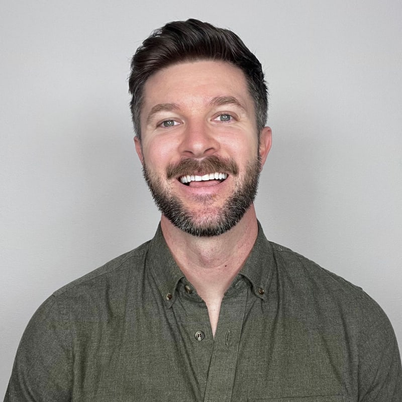 Tyler Gori, founder of Shoebill Design Studio, smiling, in a dark green shirt